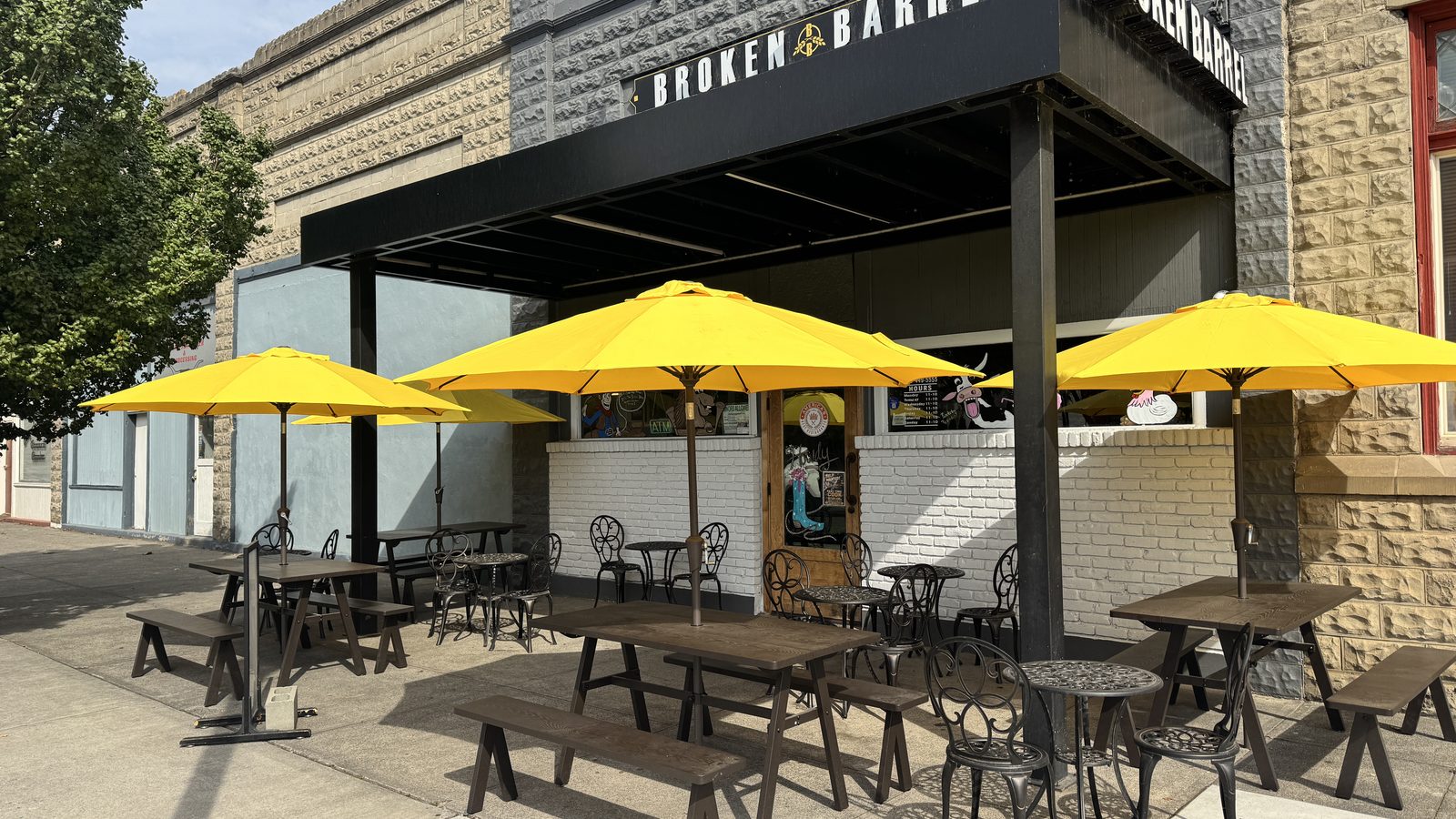 Broken Barrel on Coe Avenue in Stanfield, with patio tables under yellow umbrellas